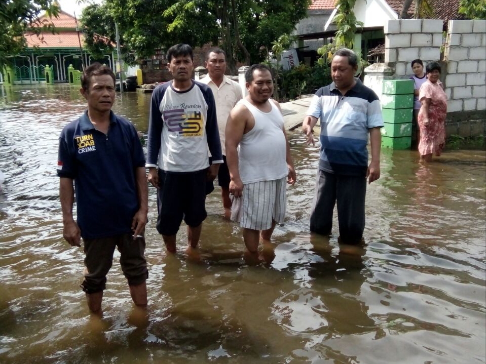 PICU BANJIR - Anggota Fraksi Golkar, M Nizar langsung terjun ke lokasi banjir yang dipicu luapan sungai setelah mendapatkan warga Desa Watugolong, Kecamatan Krian, Kabupaten Sidoarjo, Minggu (26/11/2017).