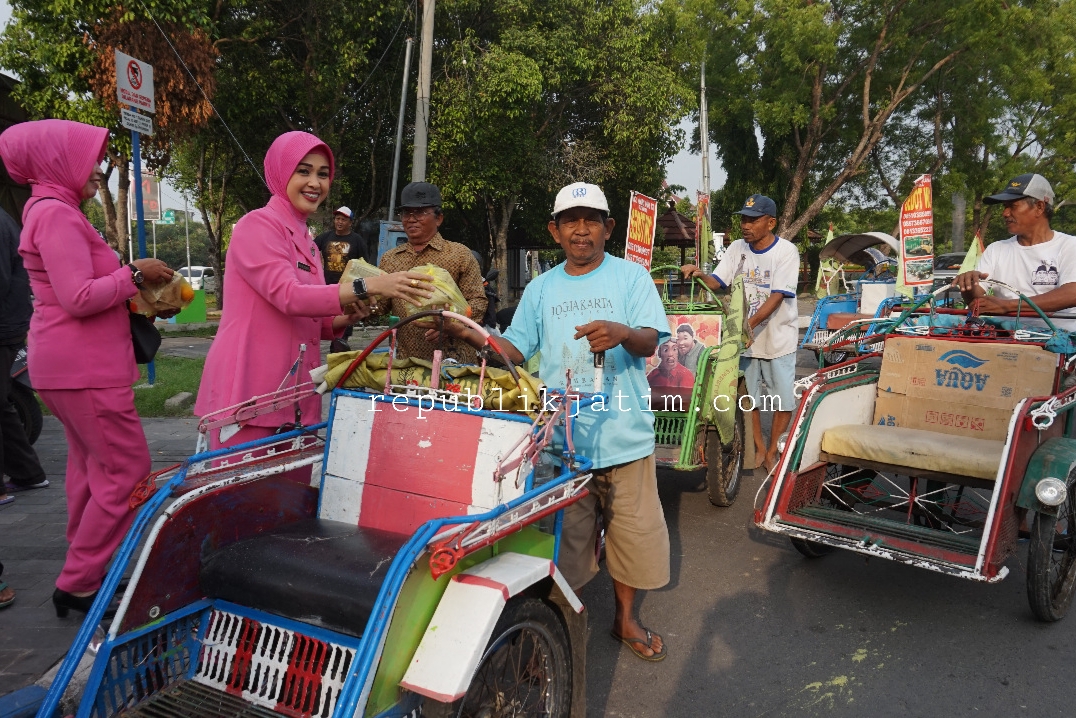 Ketua Bhayangkari cabang Ngawi, Intan Berliana Dicky membagikan paket nasi bungkus ke tukang becak di seputaran Alun-alun Ngawi (Foto/Andik)