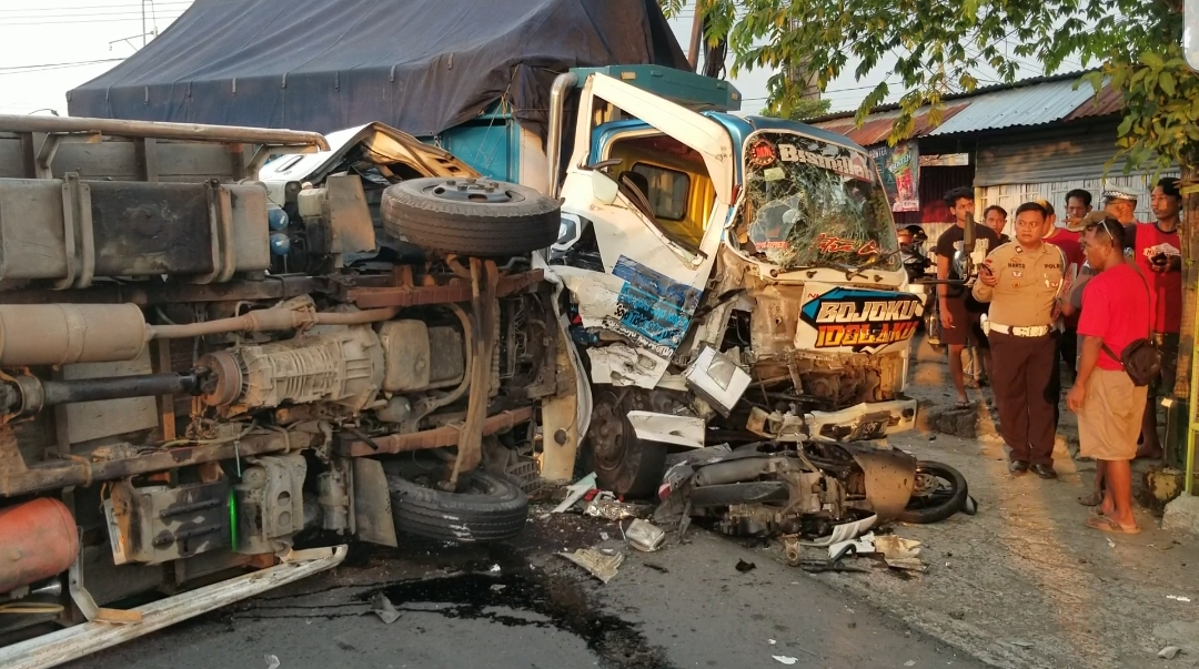 Kondisi truk bermuatan kayu jati terguling dan truk bermuatan melon berikut sepeda motor ringsek usai terlibat kecelakaan beruntun