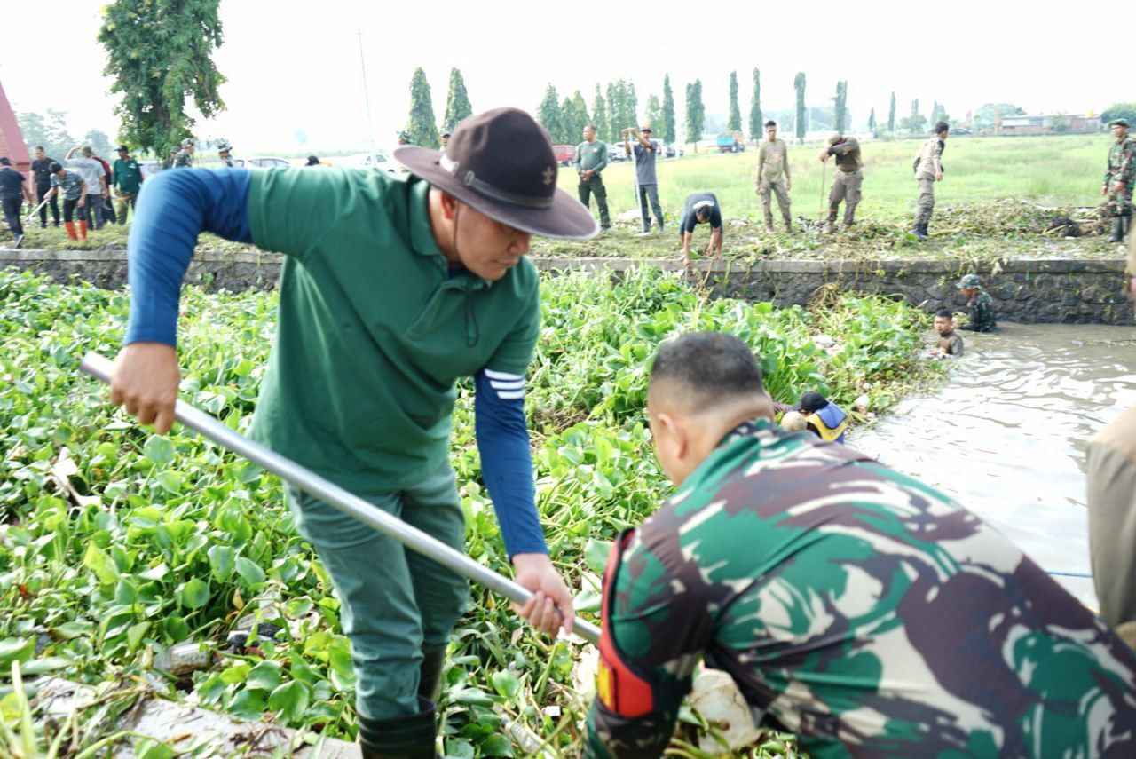 BERSIHKAN - Plt Bupati Sidoarjo, Subandi memimpin bersih-bersih sungai di Desa Candipari, Kecamatan Porong, Sidoarjo bersama 500 ASN, anggota Kodim 0816 dan para personil Polresta Sidoarjo, Minggu (12/01/2025).