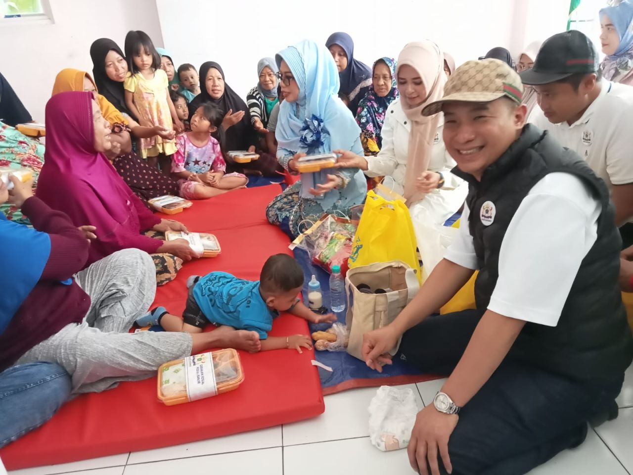 BANTUAN - Pengurus Kamar Dagang dan Industri (KADIN) Sidoarjo menyerahkan bantuan paket sembako untuk warga terdampak langganan banjir tahunan di Desa Kedungbanteng, Kecamatan Tanggulangin, Sidoarjo, Jumat (30/01/2025).