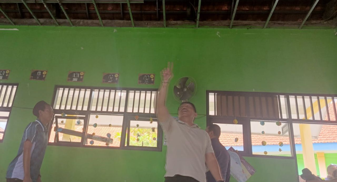 AMBRUK - Ketua Komisi D DPRD Sidoarjo, M Dhamroni Chudlori bersama sejumlah anggotanya melihat kondisi bangunan atap ruang kelas V SDN Sidodadi, Kecamatan Candi, Sidoarjo yang ambrol dikarenakan kurangnya penyangga, Sabtu (04/01/2025).