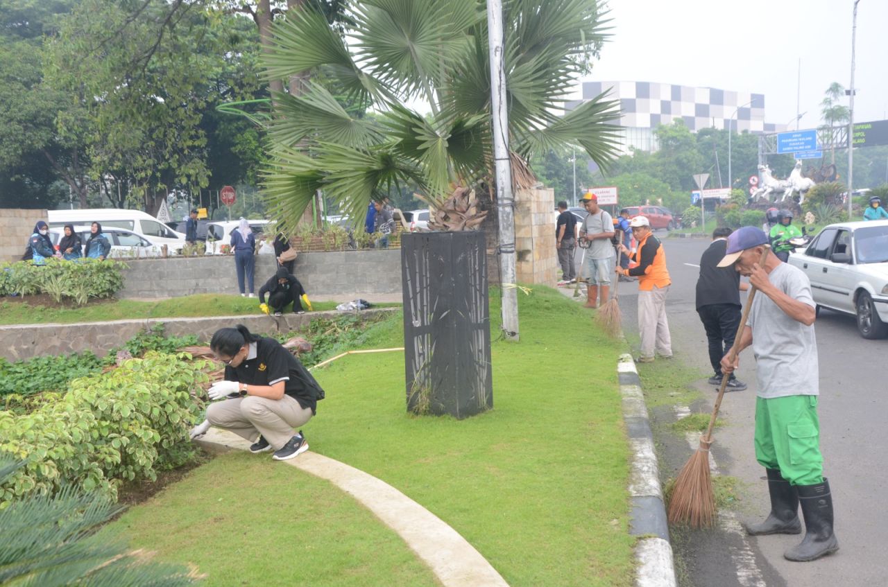 BERSIHKAN - Ratusan ASN Pemkab Sidoarjo dipimpin Sekda membersihkan taman pasif di Exit Tol Sidoarjo dan Monumen Pancasila serta jalur pedestrian dari JL Pahlawan hingga JL Thamrin, Sidoarjo Kota, Jumat (14/02/2025).