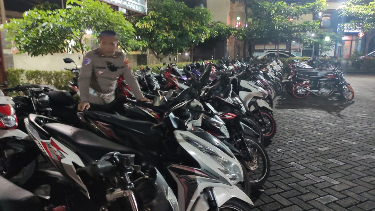 AMANKAN - Sebanyak 157 sepeda motor diamankan petugas Polresta Sidoarjo yang diduga sebagai ajang balap liar beserta penontonnya saat penggerebekan balap liar di JL Raya Arteri Porong, Kecamatan Porong, Sidoarjo, Selasa (04/03/2025) petang.