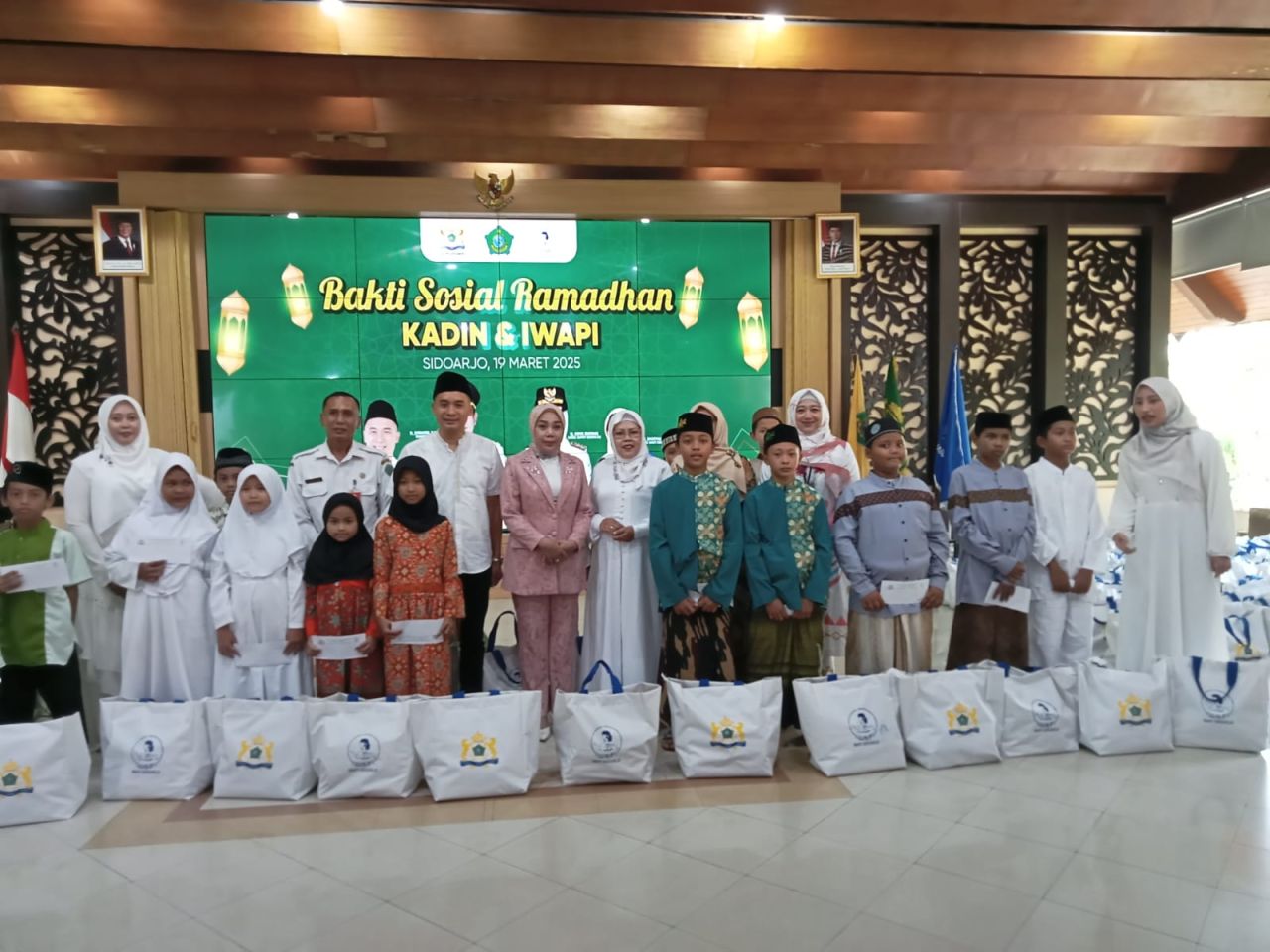 SANTUNAN - Ketua Kadin Sidoarjo Ubaidillah Nurdin dan Ketua IWAPI Shofiya bersama Ketua PKK Sidoarjo Sriatun Subandi menyerahkan bantuan dan santunan kepada 150 anak yatim piatu dari 10 yayasan yatim piatu di Pendopo Delta Wibawa, Rabu (19/03/2025).
