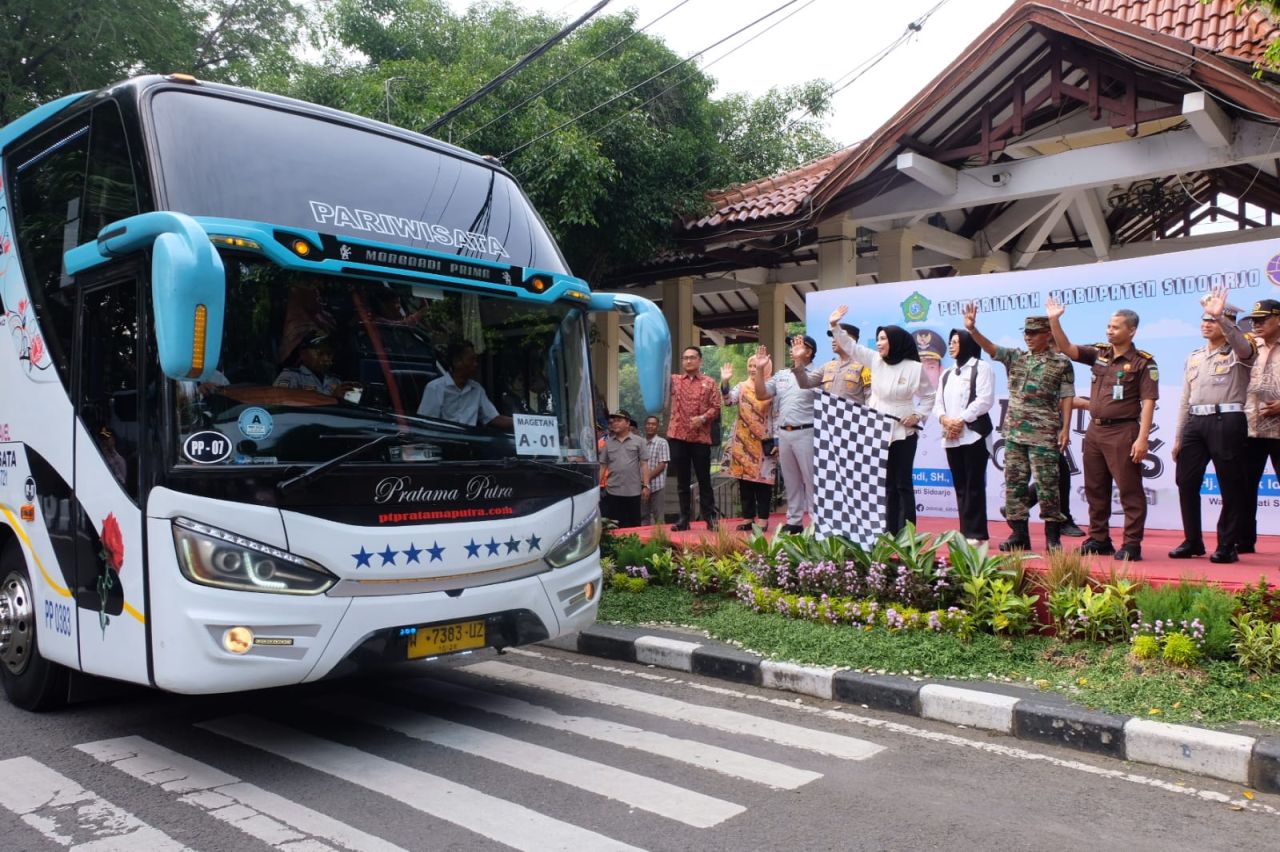 BERANGKATKAN - Dinas Perhubungan (Dishub) Pemerintah Kabupaten (Pemkab) Sidoarjo memberangkatkan rombongan mudik gratis yang dilepas Wakil Bupati (Wabup) Sidoarjo, Mimik Idayana di Alun - Alun Sidoarjo, Jumat (28/03/2025).