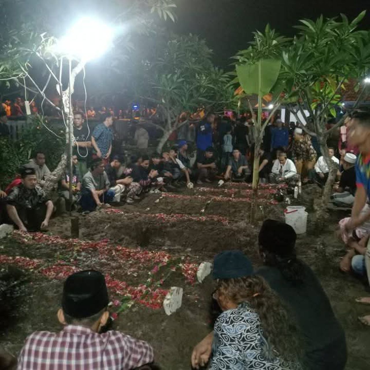 MAKAMKAN - Sebanyak 7 korban longsor jalur Pacet - Cangar, Kabupaten Mojokerto dimakamkan secara berjajar di Tempat Pemakaman Umum (TPU) Desa Kloposepuluh, Kecamatan Sukodono, Sidoarjo, Jumat (04/04/2025) malam.