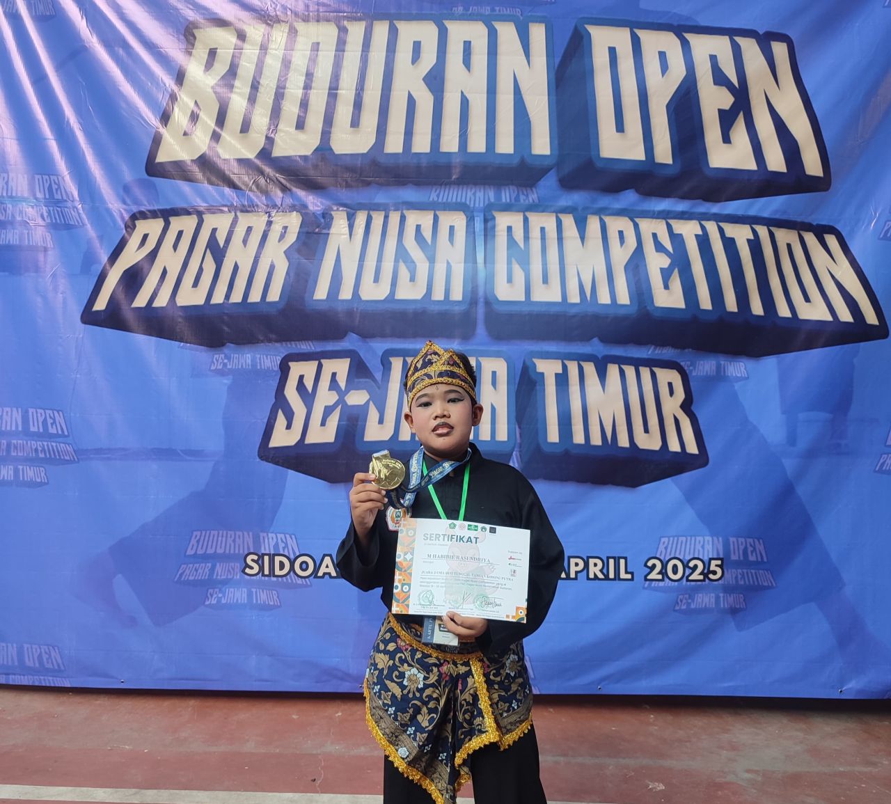 MEDALI EMAS - Muhammad Habibie Rasendriya Putra S meraih medali emas dalam ajang Kejuaraan Buduran Open Pagar Nusa Competition tang digelar PAC Pagar Nusa Kecamatan Buduran di Aula SMK 2 Antartika Sidoarjo, Jumat (18/04/2025).
