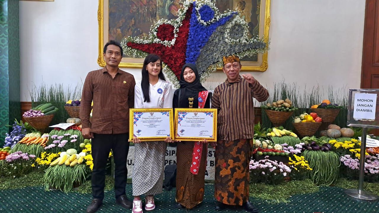 PENGHARGAAN - Kepala SMAN 4 Sidoarjo Dr Karyanto mendampingi 2 siswinya Rara Anggun Awandhini dan Rhizqi Zabrina Hariyanti yang meraih penghargaan Gubernur Jatim Khofifah Indar Parawansa di Grahadi Surabaya usai upacara Hardiknas, Jumat (02/05/2025).
