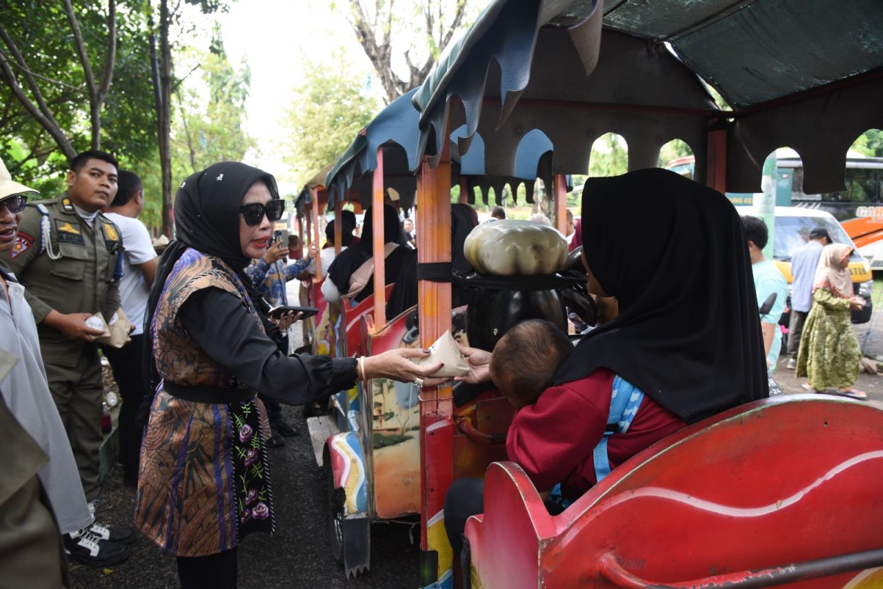 BAGI MAKANAN - Wabup Sidoarjo Mimik Idayana melaksanakan kegiatan sosial berbagi makanan gratis di JL Raya Desa Sidokerto, Kecamatan Buduran, Sidoarjo, Jumat (09/05/2025).
