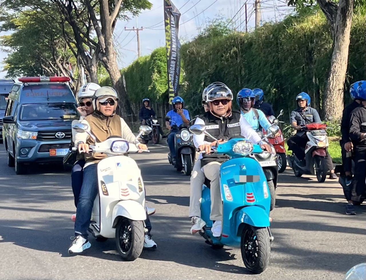 KELILING - Bupati Sidoarjo, Subandi bersama istri Ny Sriatun Subandi ikut memeriahkan acara Scooter Riding di Lanudal Juanda, Sidoarjo, Minggu (15/06/2025).
