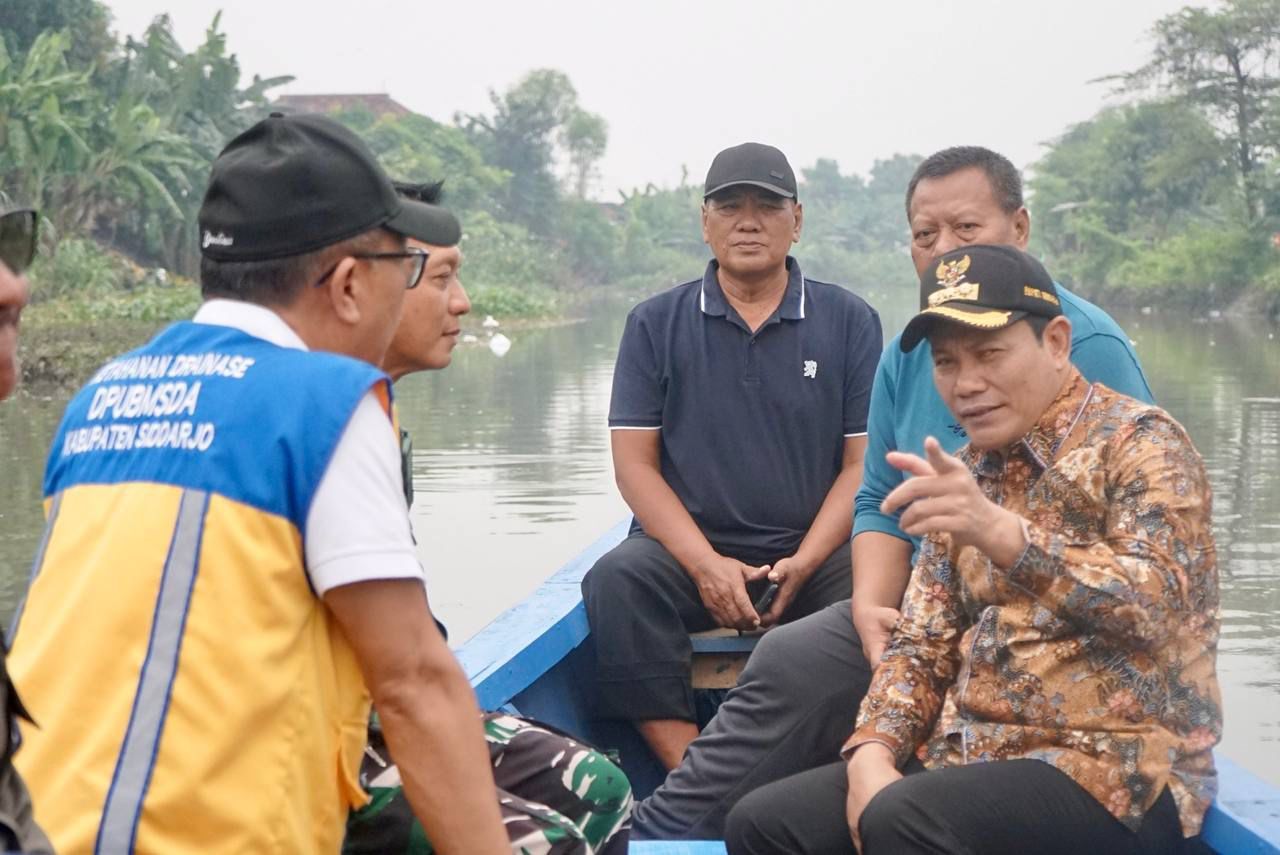 SUSUR - Bupati Sidoarjo, Subandi bersama Kepala Dinas Pekerjaan Umum Bina Marga dan Sumber Daya Air (PUBM dan SDA) dan pejabat Pemkab Sidoarjo menyusuri sungai Mbah Gepuk dari Ngaban (Tanggulangin) hingga Kedungpeluk (Candi), Jum'at (20/06/2025).