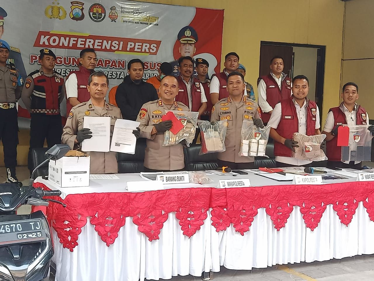 OTT - Meski terkesan lamban akhirnya penyidik Satuan Reskrim Polresta Sidoarjo merilis kasus dugaan OTT penjaringan perangkat di Kecamatan Tulangan dengan barang bukti Rp 1 miliar lebih bersama tiga tersangka dan barang bukti lainnya, Senin (23/06/2025).