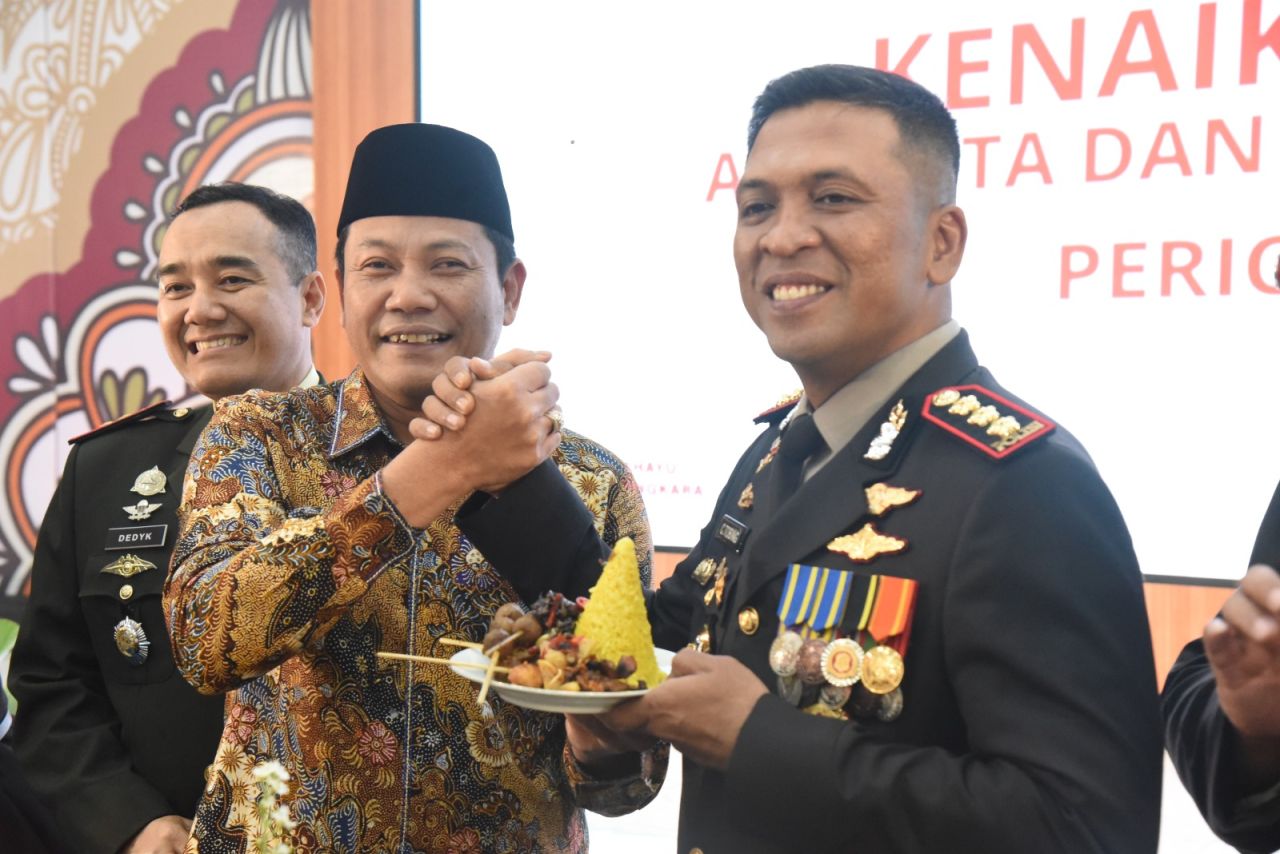 TUMPENG - Bupati Sidoarjo Subandi menyerahkan potong tumpeng selamatan Hari Bhayangkara ke 79 di Mako Polresta Sidoarjo kepada Kapolresta Sidoarjo, Selasa (01/07/2025).