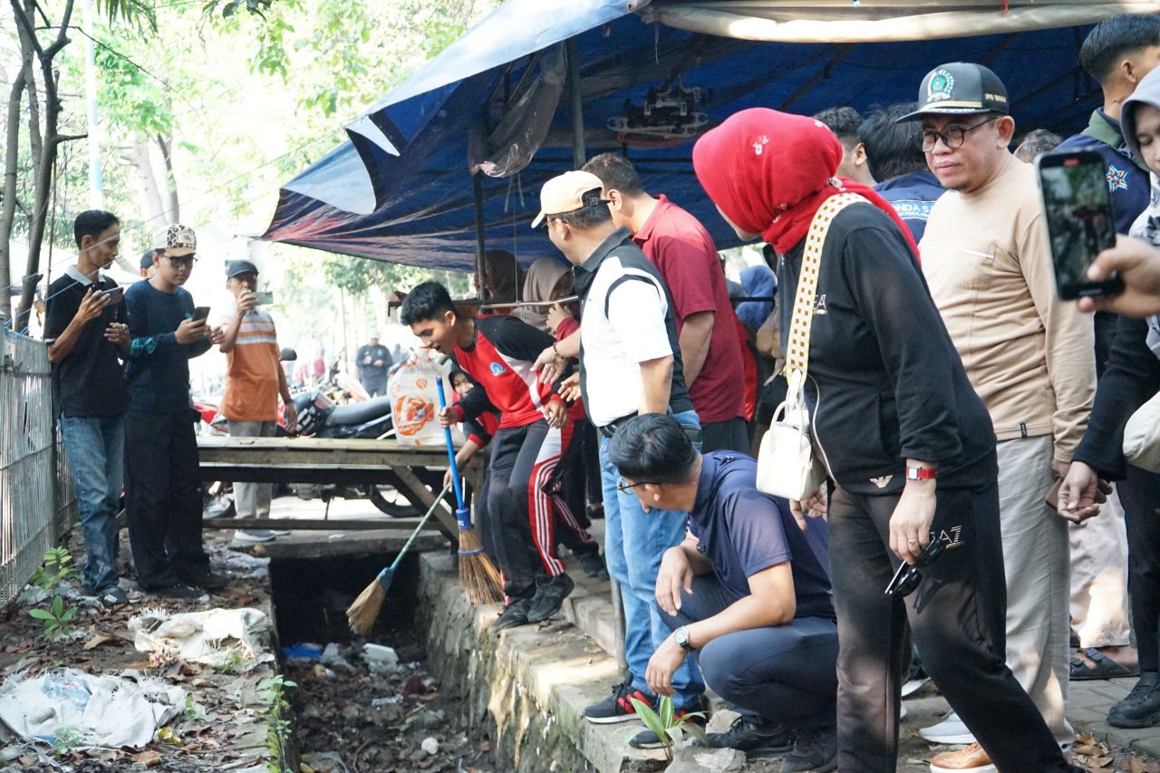 KERJA BAKTI - Wabup Sidoarjo Mimik Idayana turun lapangan dalam kegiatan kerja bakti bersama ribuan siswa SMA Negeri 2 Sidoarjo, petugas DLHK serta Satpol PP di sepanjang Taman Pinang dan Gading Fajar, Sabtu (19/06/2025).