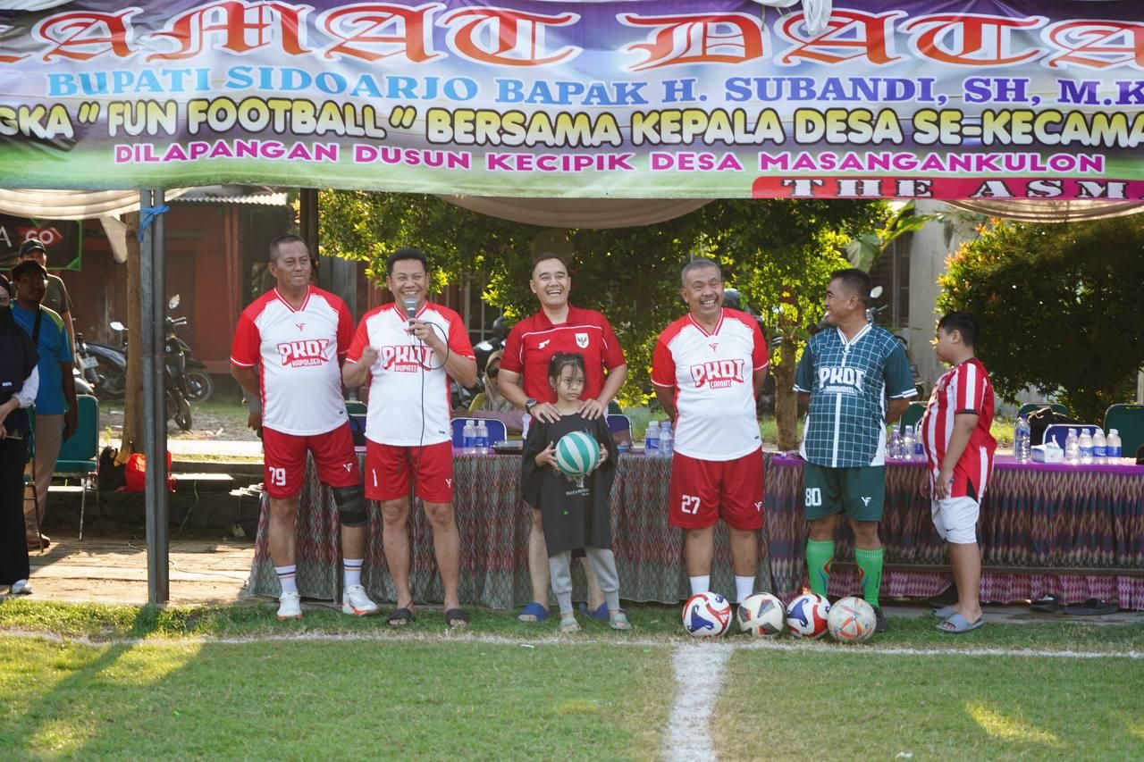 TANDING - Bupati Sidoarjo Subandi dan Dandim 0816 Letkol Inf Dedyk Wahyu Widodo ikut fun football dengan Persaudaraan Kepala Desa Indonesia (PKDI) Kecamatan Sukodono di Lapangan Sepakbola Desa Masangan Kulon, Kecamatan Sukodono, Jumat (25/07/2025).