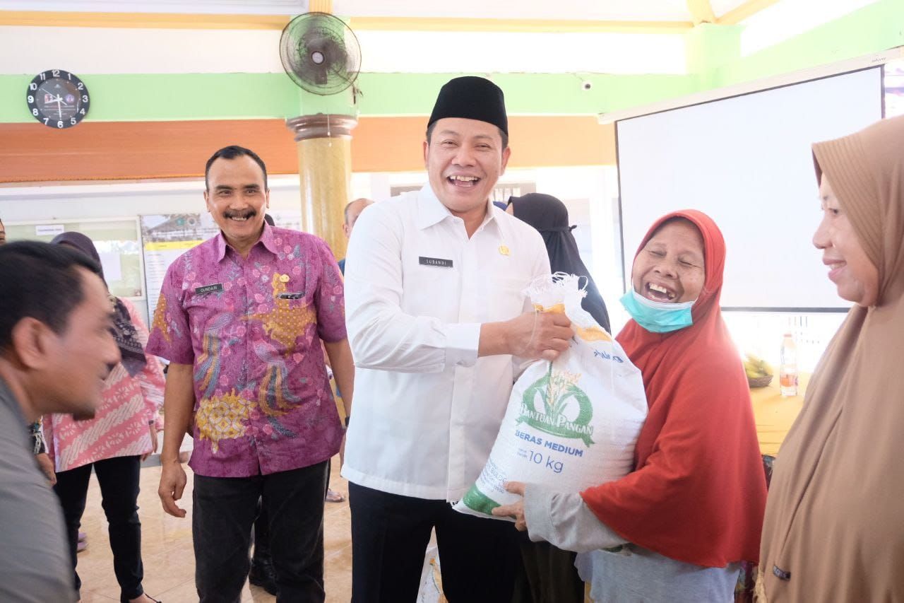 SERAHKAN - Bupati Sidoarjo Subandi menyerahkan bantuan pangan beras untuk warga Desa Kemiri, Kelurahan Sidokare dan Kelurahan Lemahputro, Kecamatan Sidoarjo sebesar 20 kilogram beras, Jumat (01/08/2025).