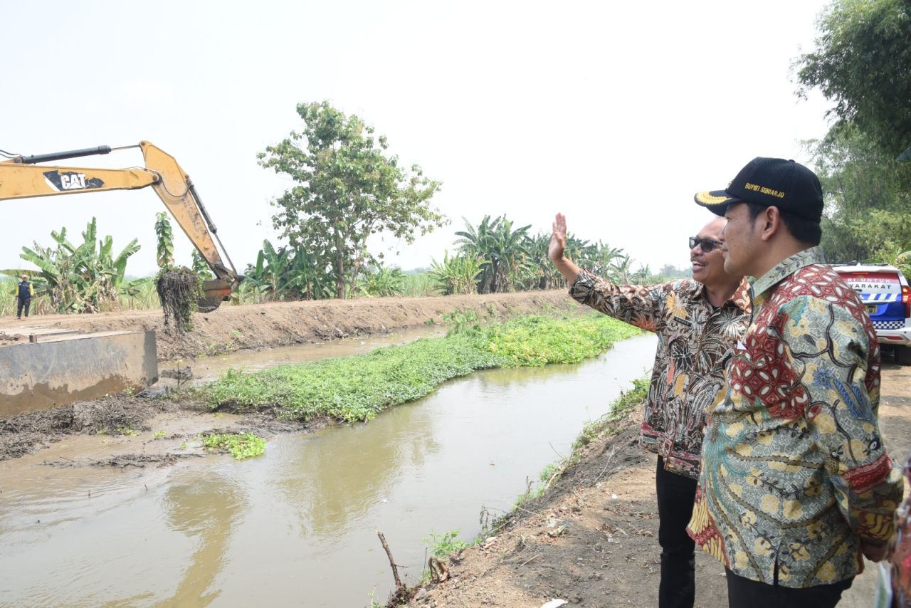 NORMALISASI - Bupati Sidoarjo Subandi memantau langsung pengerjaan normalisasi di sepanjang Sungai Kanal Porong hingga perbatasan Kecamatan Krembung, Sidoarjo, Selasa (05/08/2025).