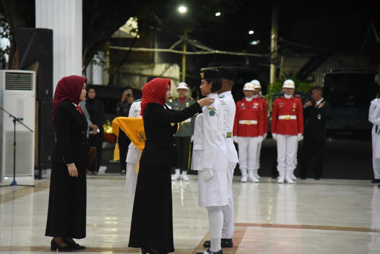 PENGUKUHAN - Wabup Sidoarjo Mimik Idayana mengukuhkan 76 anggota Pasukan Pengibar Bendera Pusaka (Paskibraka) Kabupaten Sidoarjo Tahun 2025 dalam prosesi yang digelar secara khidmat di Pendopo Delta Wibawa, Jumat (15/08/2025) malam.