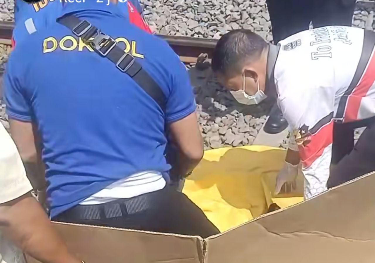 EVAKUASI - Sejumlah petugas dan warga mengevakuasi jenazah perempuan yang diperkirakan berusia 50 tahun yang tewas tertabrak Kereta Api (KA) Jenggala di depan Maspion III, Desa Tebel, Kecamatan Gedangan, Sidoarjo, Rabu (06/08/2025).