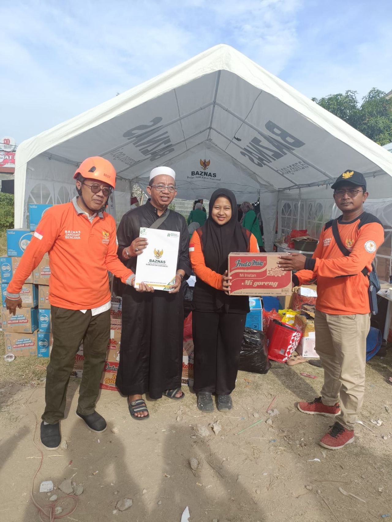 SERAHKAN - Ketua Takmir Masjid SSNR Perum Magersari Permai menyerahkan bantuan peralatan salat dan makin di Posko Ponpes Al Khoziny Buduran, Sidoarjo, Sabtu (05/10/2025).