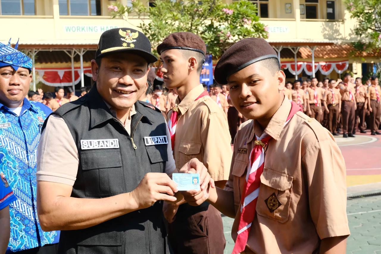SERAHKAN - Bupati Sidoarjo Subandi menyerahkan e KTP baru bagi kalangan pelajar Sidoarjo yang sudah jadi dan dicetak Dispendukcapil Pemkab Sidoarjo beberapa waktu lalu.