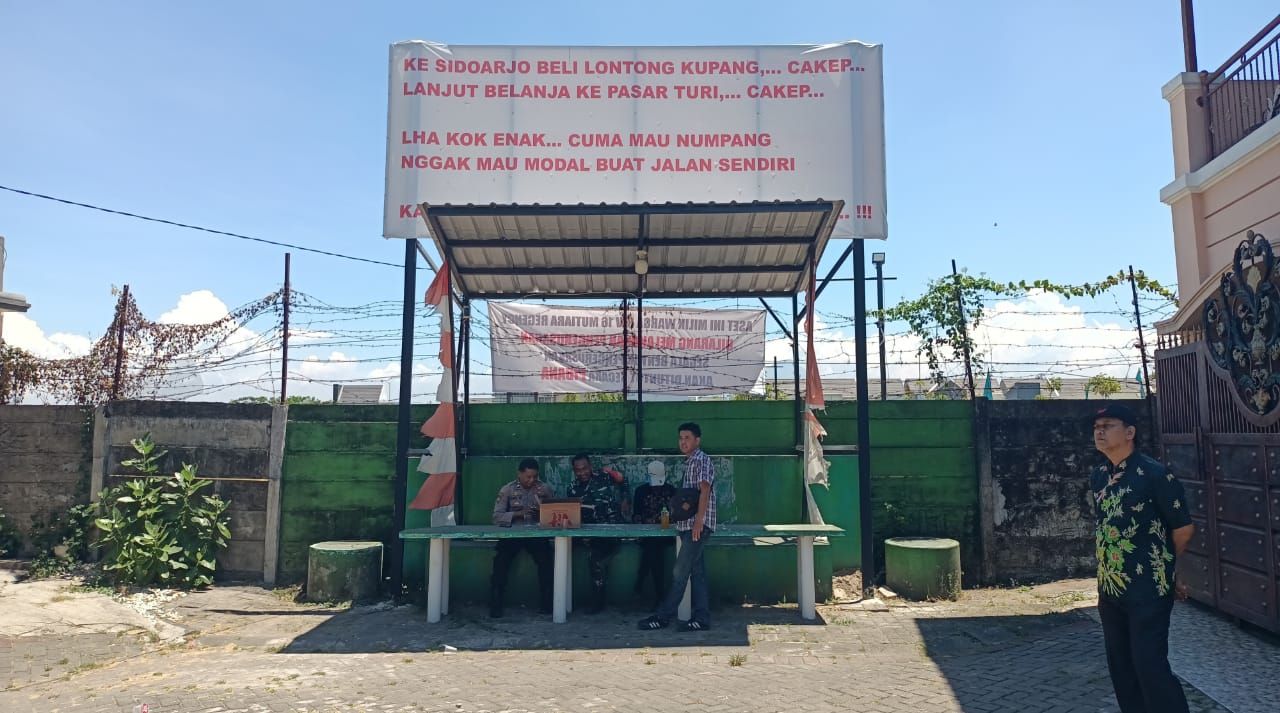 JALAN TEMBUS - Tembok batas di Perumahan Mutiara Regency inilah yang diminta Perumahan Mutiara City untuk dijebol sebagai jalan tembus antar perumahan yang saat ini dipasang spanduk oleh warga Perumahan Mutiara City, Rabu (29/10/2025).
