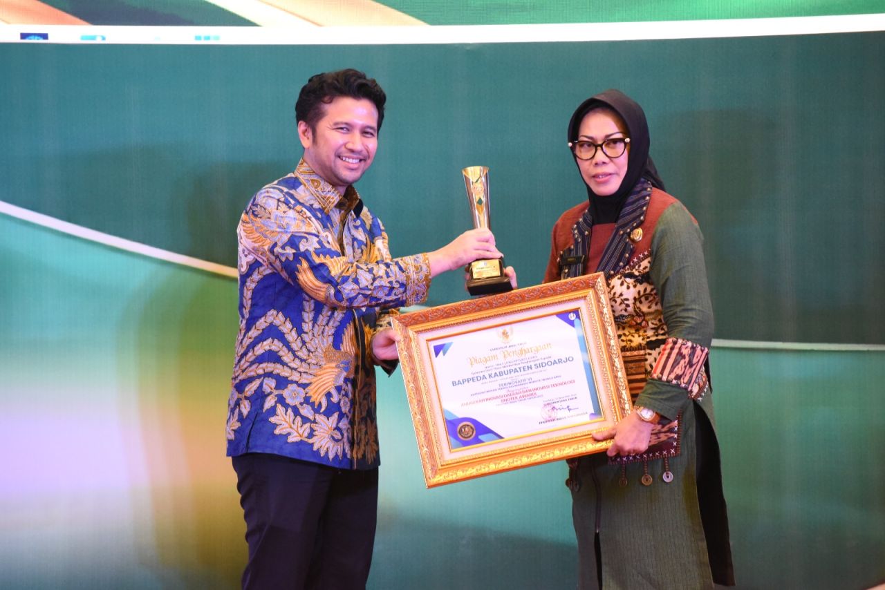 PENGHARGAAN - Tiga inovasi Pemkab Sidoarjo meraih penghargaan Inovasi Teknologi (Inotek) Award Jatim 2025 dari Badan Riset dan Inovasi Daerah (Brida) Jatim yang diterima Sekda Fenny Apridawati dari Wagub Jatim Emil E Dardak di Hotel Mercure Surabaya.