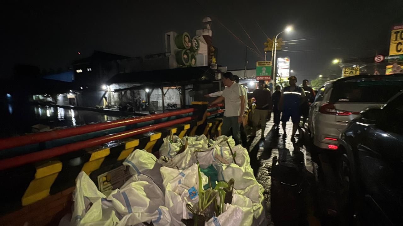 BERSIHKAN - Bupati Sidoarjo Subandi turun ke lapangan untuk memantau aliran air dan menemukan penumpukan sampah signifikan di sekitar Jembatan Kuthuk, kawasan Sidokare, Kecamatan Sidoarjo, Rabu (19/11/2025) malam.