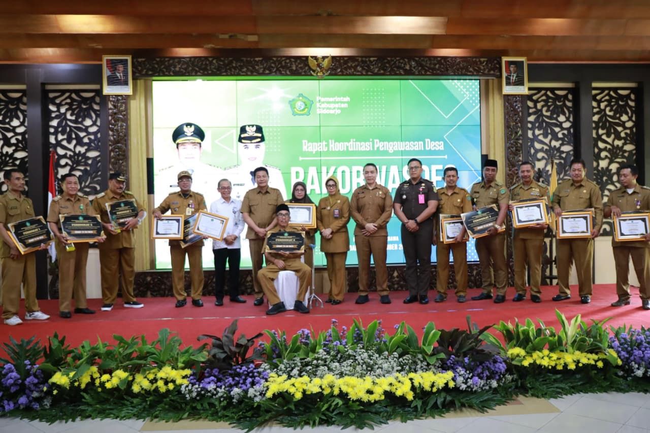 RAKOR - Bupati Sidoarjo Subandi memberi apresiasi kepada 10 desa yang berhasil menjadi nominator penilaian tata kelola desa dengan predikat sangat memadai Tahun 2024 saat Rakorwasdes di Pendopo Delta Wibawa, Senin (24/11/2025).