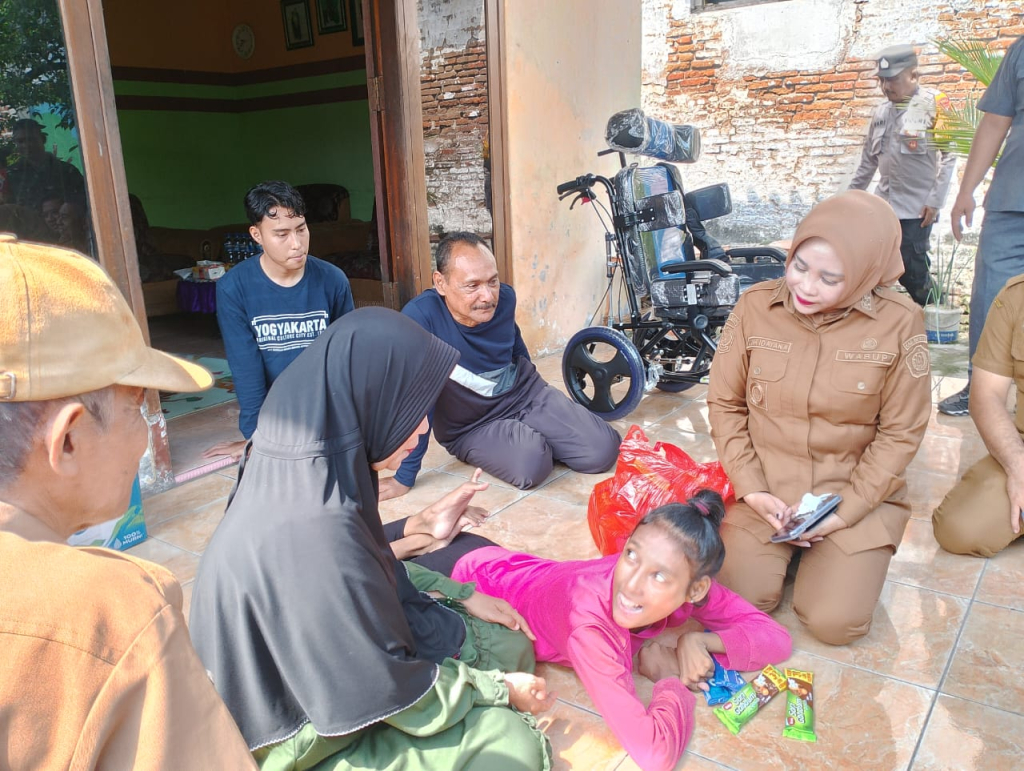 SERAHKAN - Wabup Sidoarjo Mimik Idayana didampingi pejabat Dinasos menyerahkan bantuan kursi roda untuk warga Desa Kepatihan dan Desa Tulangan, Kecamatan Tulangan, Sidoarjo, Senin (29/12/2025).