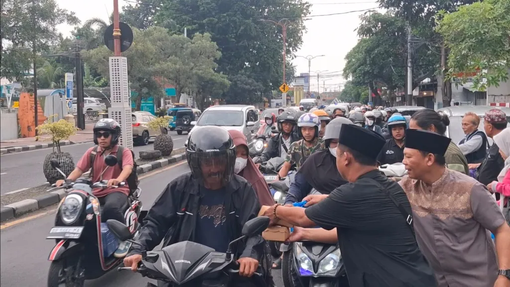BAGI TAKJIL - Pengurus dan anggota PWI Sidoarjo memanfaatkan bulan Suci Ramadhan dengan membagikan ratusan takjil kepada pengguna jalan yang melintas depan Balai Wartawan Sidoarjo, Selasa (10/03/2026).
