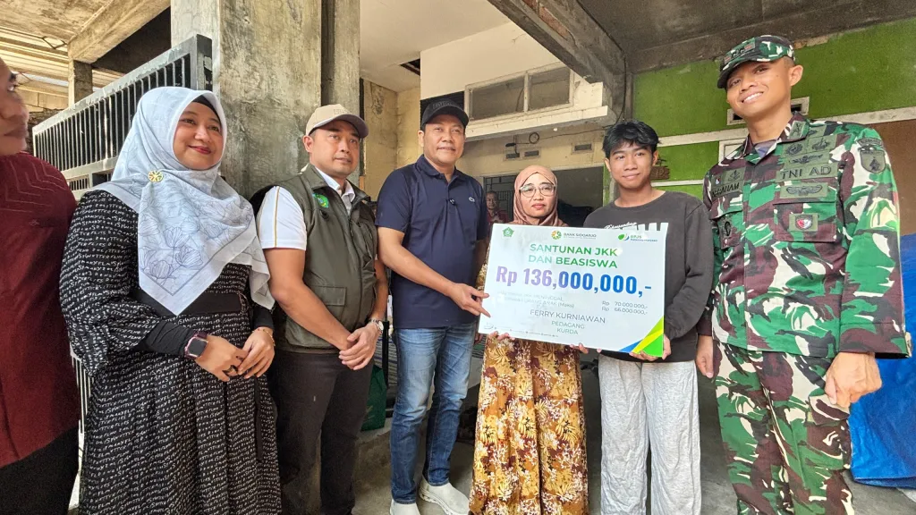 SANTUNAN - Bupati Sidoarjo Subandi menyerahkan santunan Rp 136 juta kepada ahli waris pedagang yang mengalami kecelakaan kerja di Desa/Kecamatan Tulangan, Sidoarjo di rumah ahli waris, Sabtu (18/07/2026).