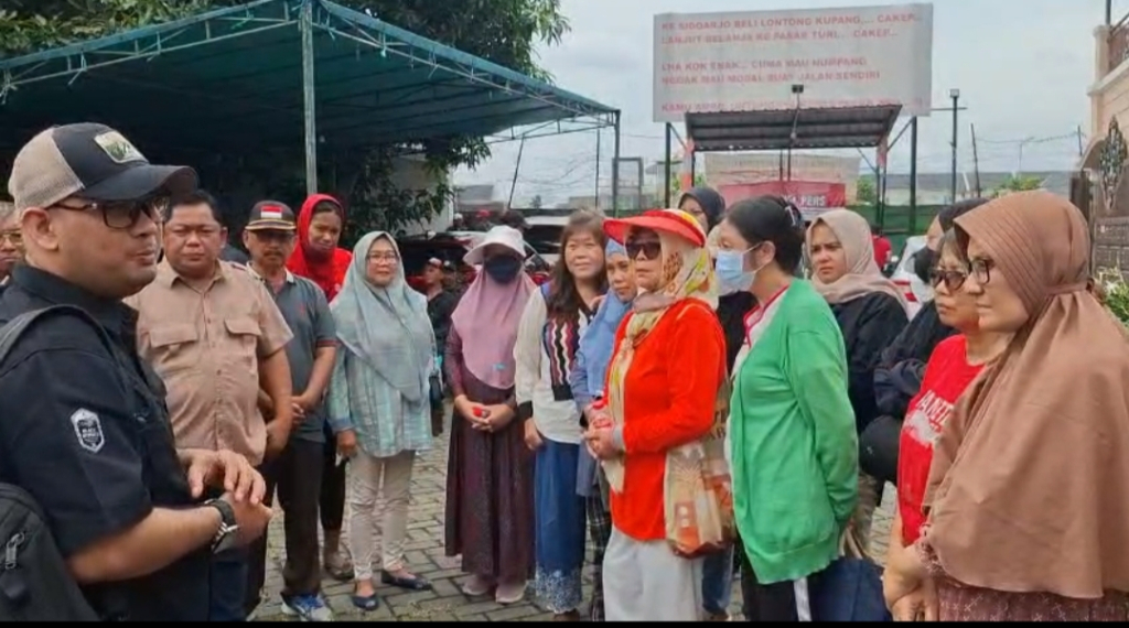 SIAGA - Ratusan warga Perumahan Mutiara Regency sejak pagi sudah bersiaga di tembok pembatas perumahan usai mendengar ada rencana pembongkaran tembok di ujung perumahan mereka itu, Rabu (28/01/2026).