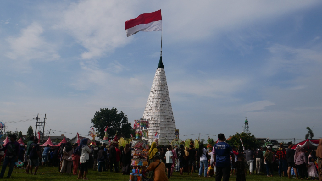 TEMPE - Tradisi ruwah desa (sedekah bumi) warga Desa Sedengan Mijen, Kecamatan Krian, setiap menjelang datangnya bulan Suci Ramadhan dengan rebutan tumpeng tempe raksasa 14 meter di lapangan desa setempat, Minggu (01/02/2026).