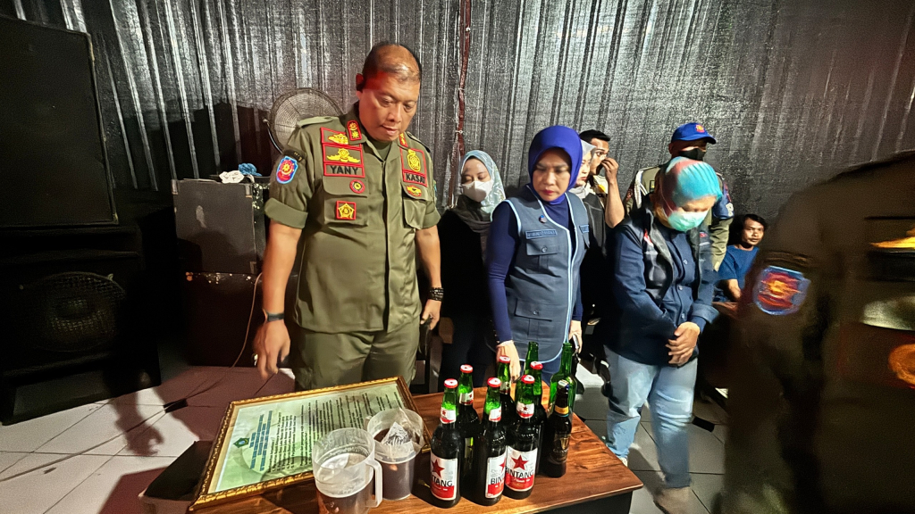 MIRAS - Wabup Sidoarjo Mimik Idayana dan Kasatpol PP Yany Setiawan didampingi Kades Lebo menunjukkan miras hasil razia di kafe karaoke yang berdiri di atas Tanah Kas Desa (TKD) Lebo, Kecamatan Sidoarjo, Sabtu (11/07/2026) malam.