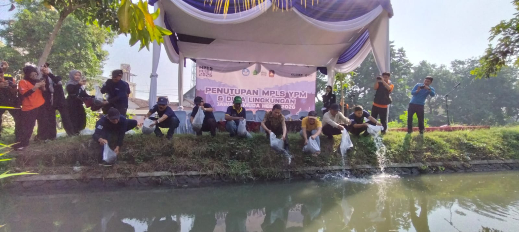 TEBAR BENIH - Secara simbolis Kepala SMK YPM 8 Sidoarjo Dr Kisyanto, SE M Pd bersama para guru dan tamu undangan melepas 18.000 benih ikan lele ke aliran sungai yang dibersihkan di Desa Sarirogo, Kecamatan Sidoarjo, Jumat (17/07/2026).