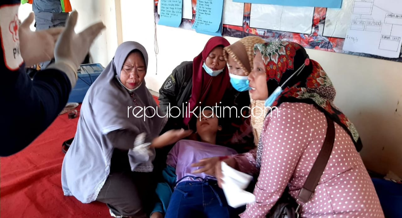 PINGSAN - Salah satu keluarga Ach Dafin Affandi (18) warga Desa Terungwetan, Kecamatan Krian, Sidoarjo langsung pingsan saat melihat proses pencarian di Long Storage Kalimati, Minggu (14/03/2021). 