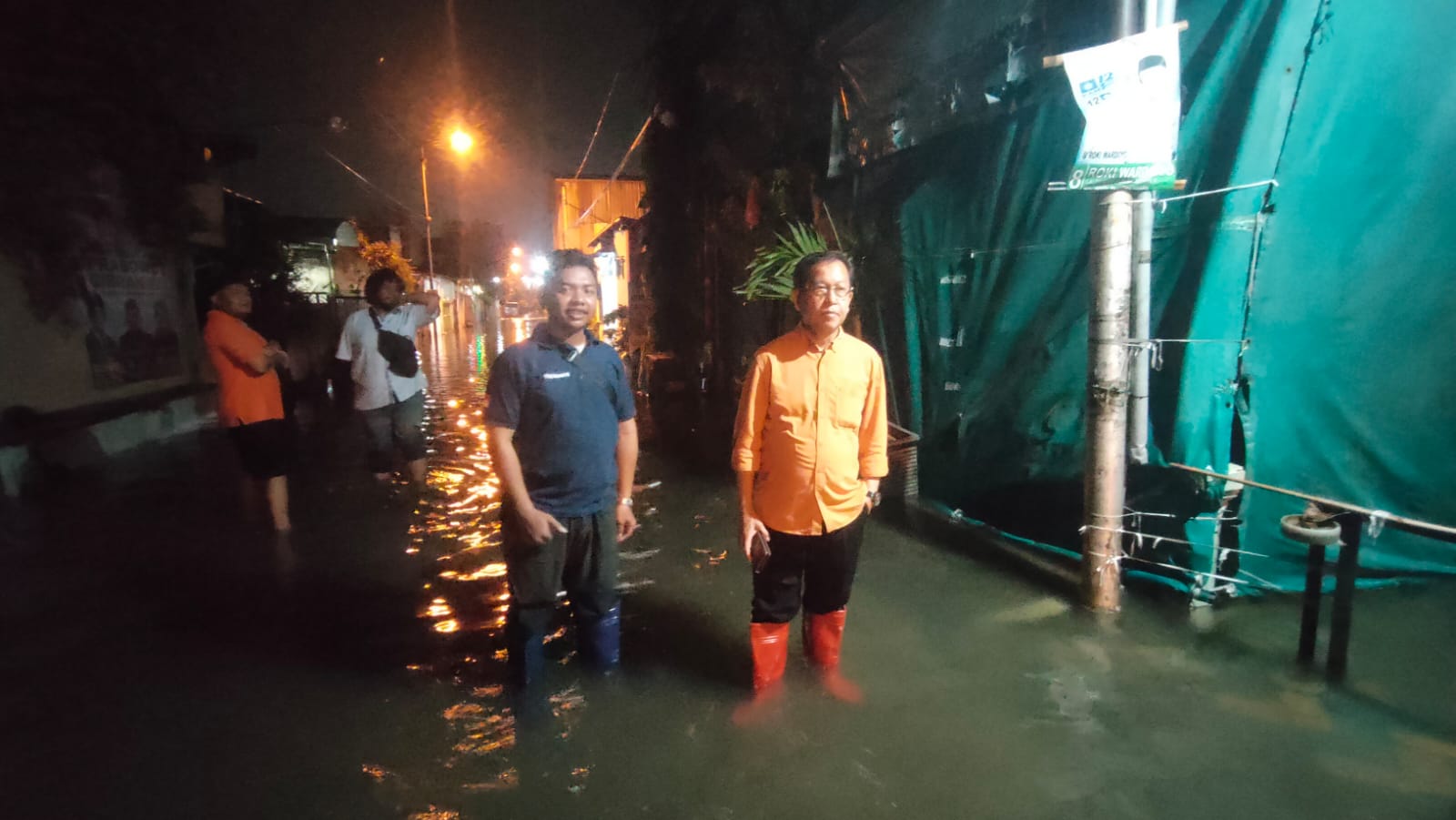 BANTUAN - Kepala Badan Penanggulangan Bencana Daerah (BPBD) Pemkab Sidoarjo, Dwijo Prawito bersama Camat Waru, Nawari memantau dan memberikan bantuan untuk korban banjir di Kecamatan Waru, Rabu (07/02/2024) dini hari.