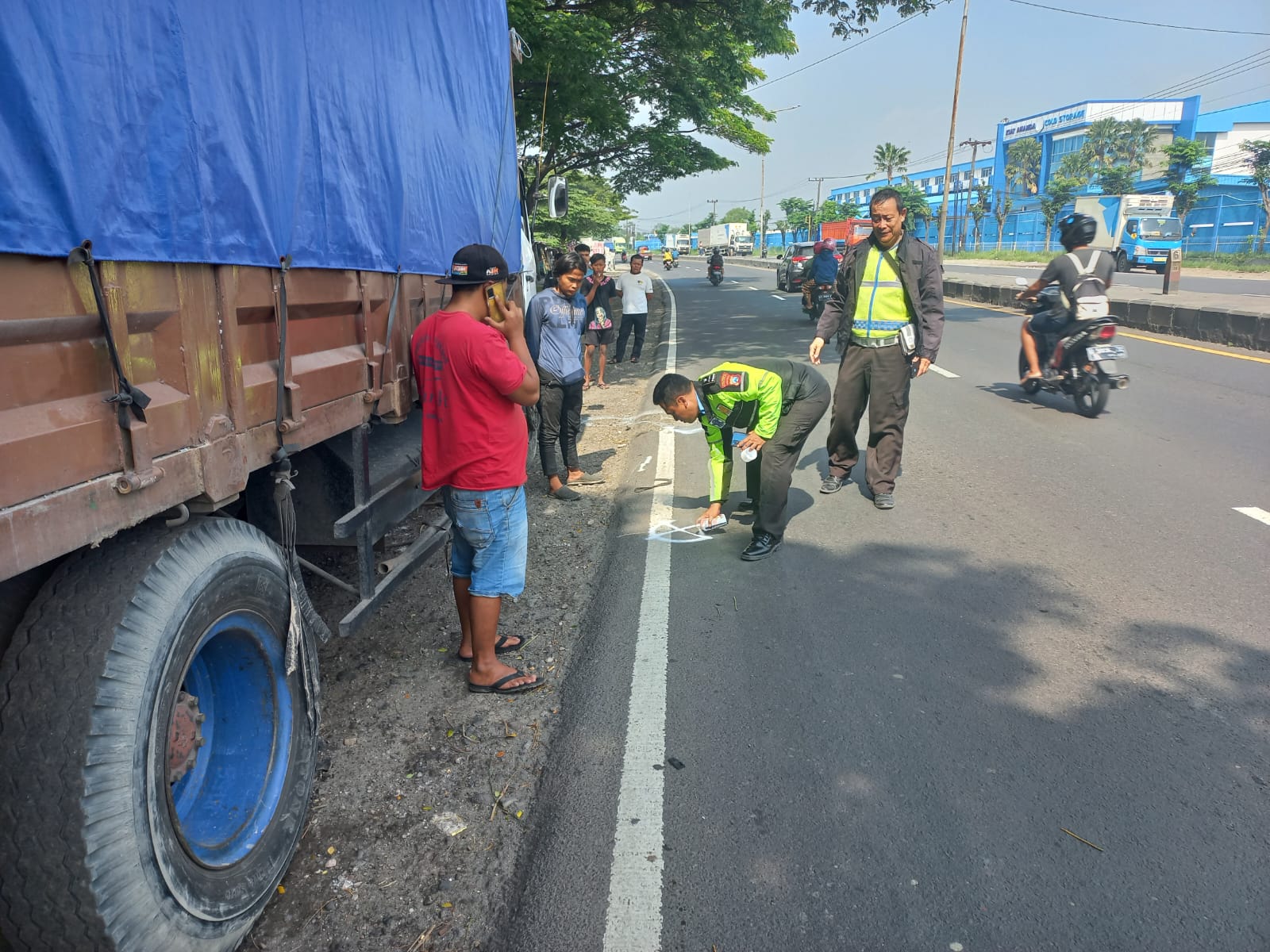 OLAH TKP - Petugas Unit Gakkum, Satuan Lantas, Polresta Sidoarjo menggelar olah TKP kecelakaan antara pria yang mengganti ban truk dan truk trailer di JL Raya Bypass Krian, Kecamatan Krian, Sidoarjo, Rabu (21/02/2024).