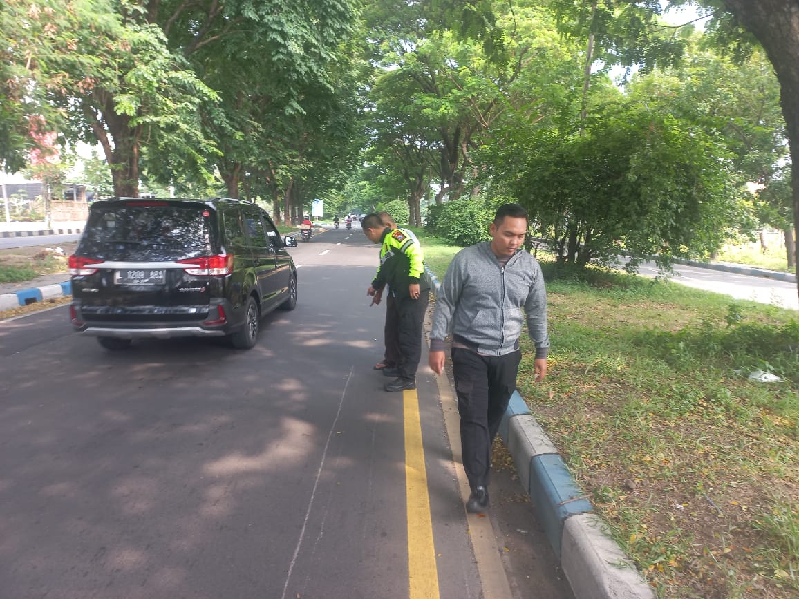 OLAH TKP - Sejumlah petugas Unit Gakkum, Satuan Lantas, Polresta Sidoarjo menggelar olah TKP kecelakaan motor diseruduk mobil L 300 di JL Raya Juanda, Kecamatan Gedangan, Sidoarjo, Rabu (21/02/2024).