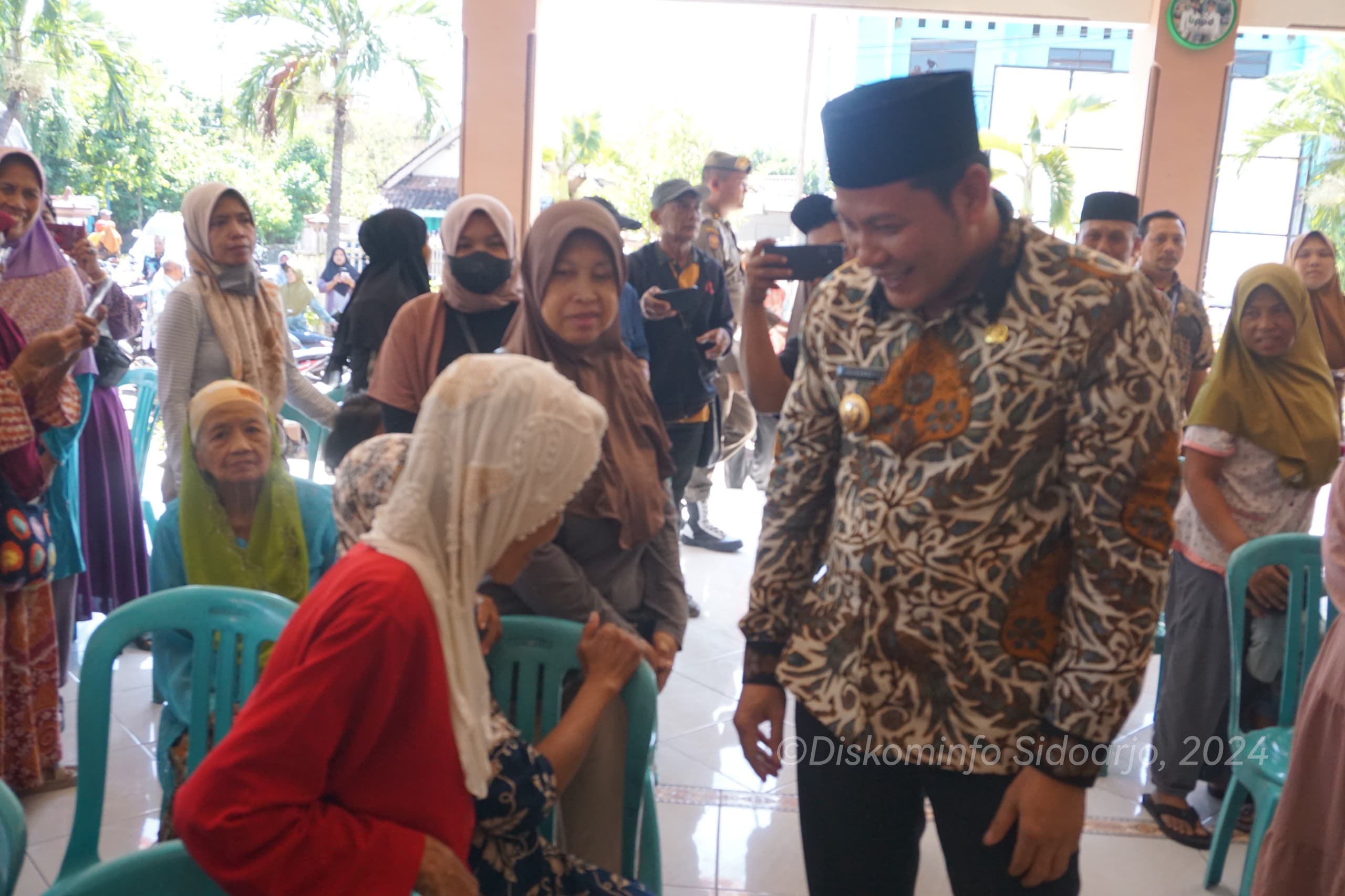 BAGIKAN - Plt Bupati Sidoarjo, Subandi menyalurkan bantuan pangan beras 10 kilogram per penerima untuk ribuan warga di 4 desa di Kecamatan Tulangan, Sidoarjo, Kamis (20/06/2024).