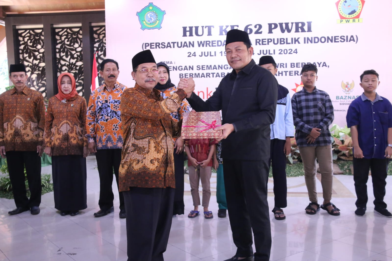 HUT - Plt Bupati Sidoarjo, Subandi memasuki Pendopo Delta Wibawa dalam peringatan HUT ke 62 Persatuan Wredhatama Republik Indonesia (PWRI) Tahun 2024 disambut Ketua PWRI MG Hadi Sutjipto, Rabu (24/07/2024). 