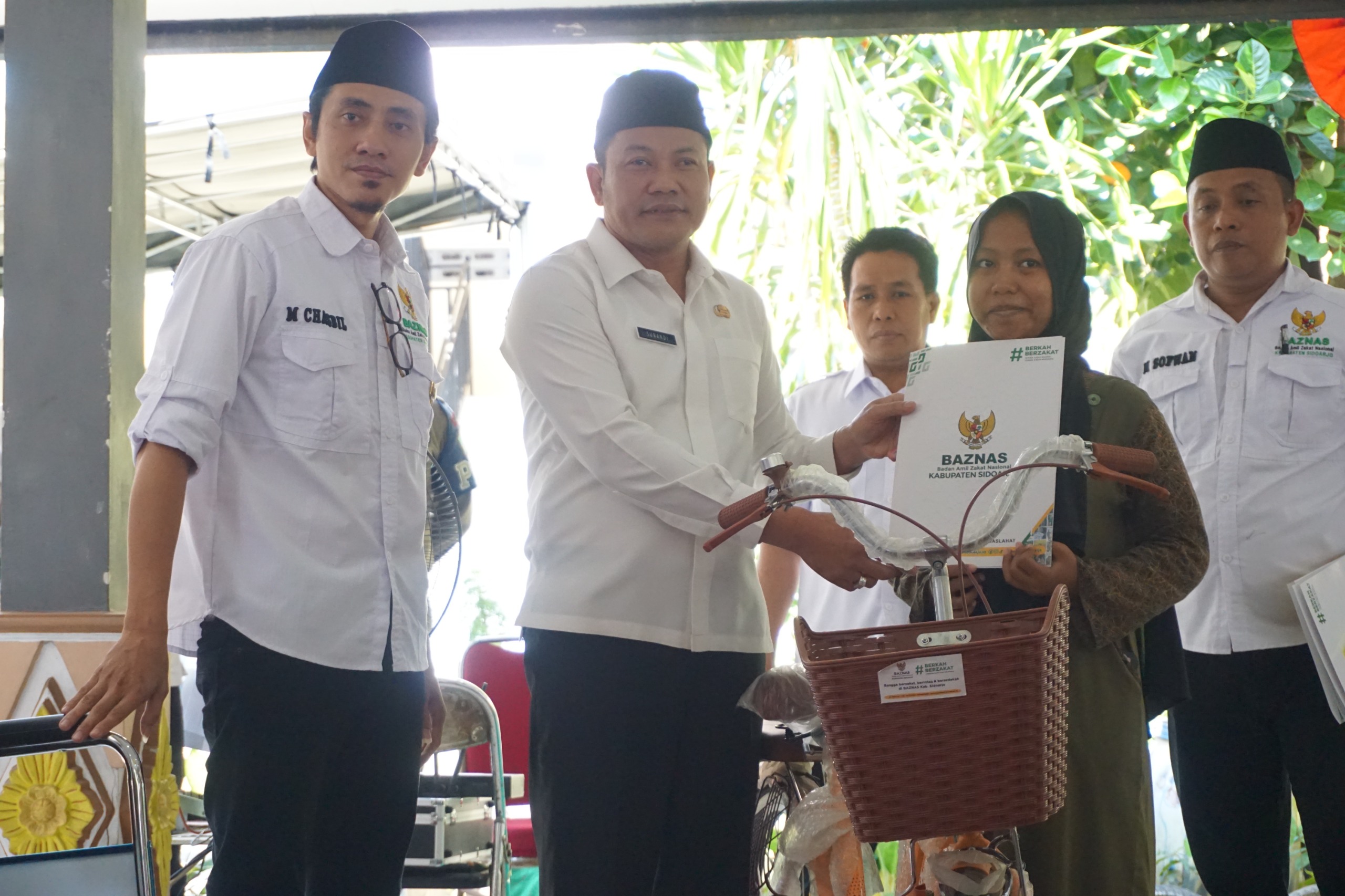 SERAHKAN - Plt Bupati Sidoarjo, Subandi bersama Baznas Sidoarjo menyerahkan berbagai bentuk bantuan untuk 247 warga di Kecamatan Tarik, Sidoarjo, Rabu (31/07/2024).