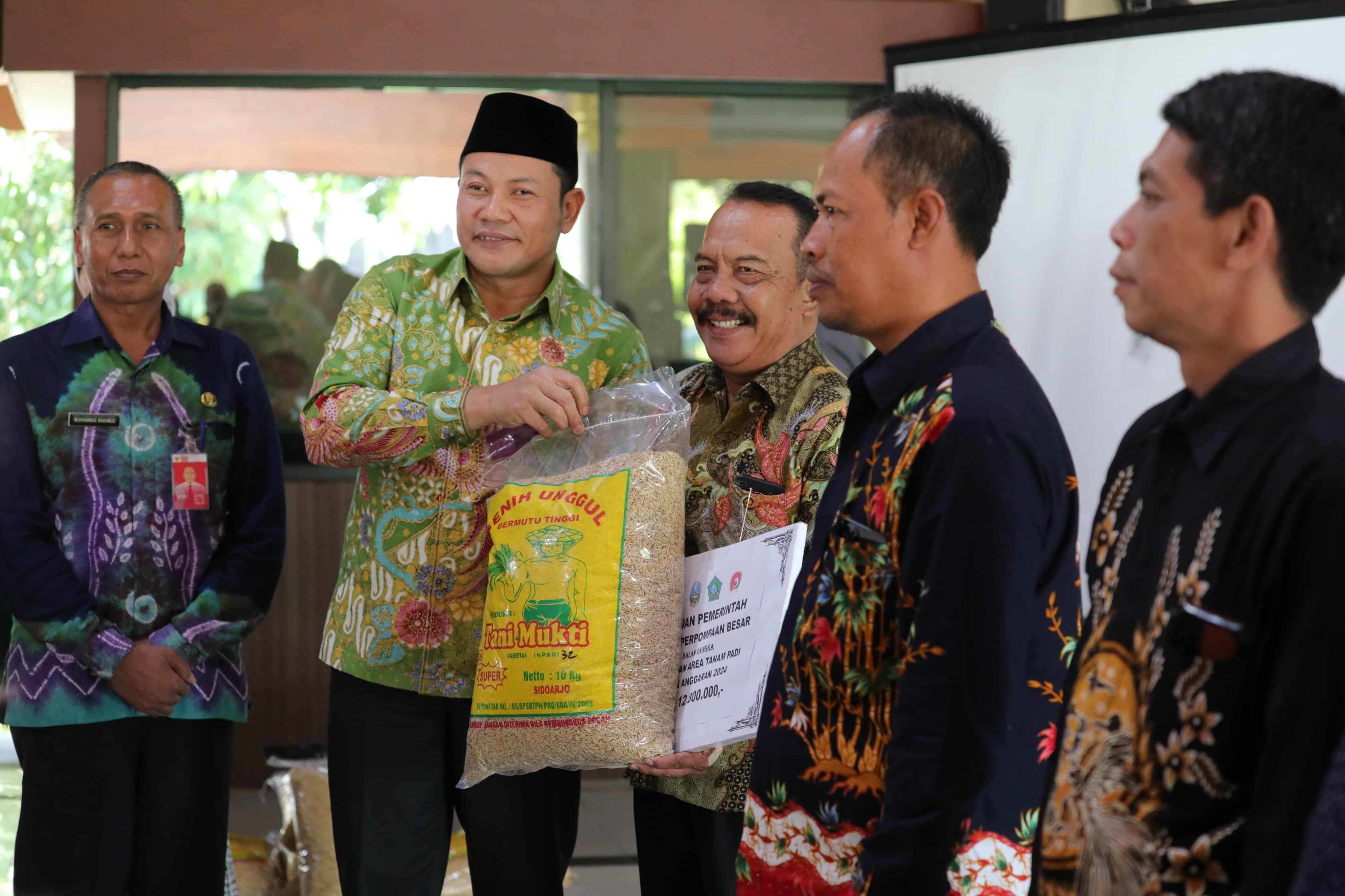 SERAHKAN - Plt Bupati Sidoarjo, Subandi menyerahkan bantuan irigasi perpompaan besar senilai Rp 112,8 juta per kelompok mencakup 90 titik kelompok tani di 16 kecamatan di wilayah Sidoarjo, Jumat (02/08/2024). 