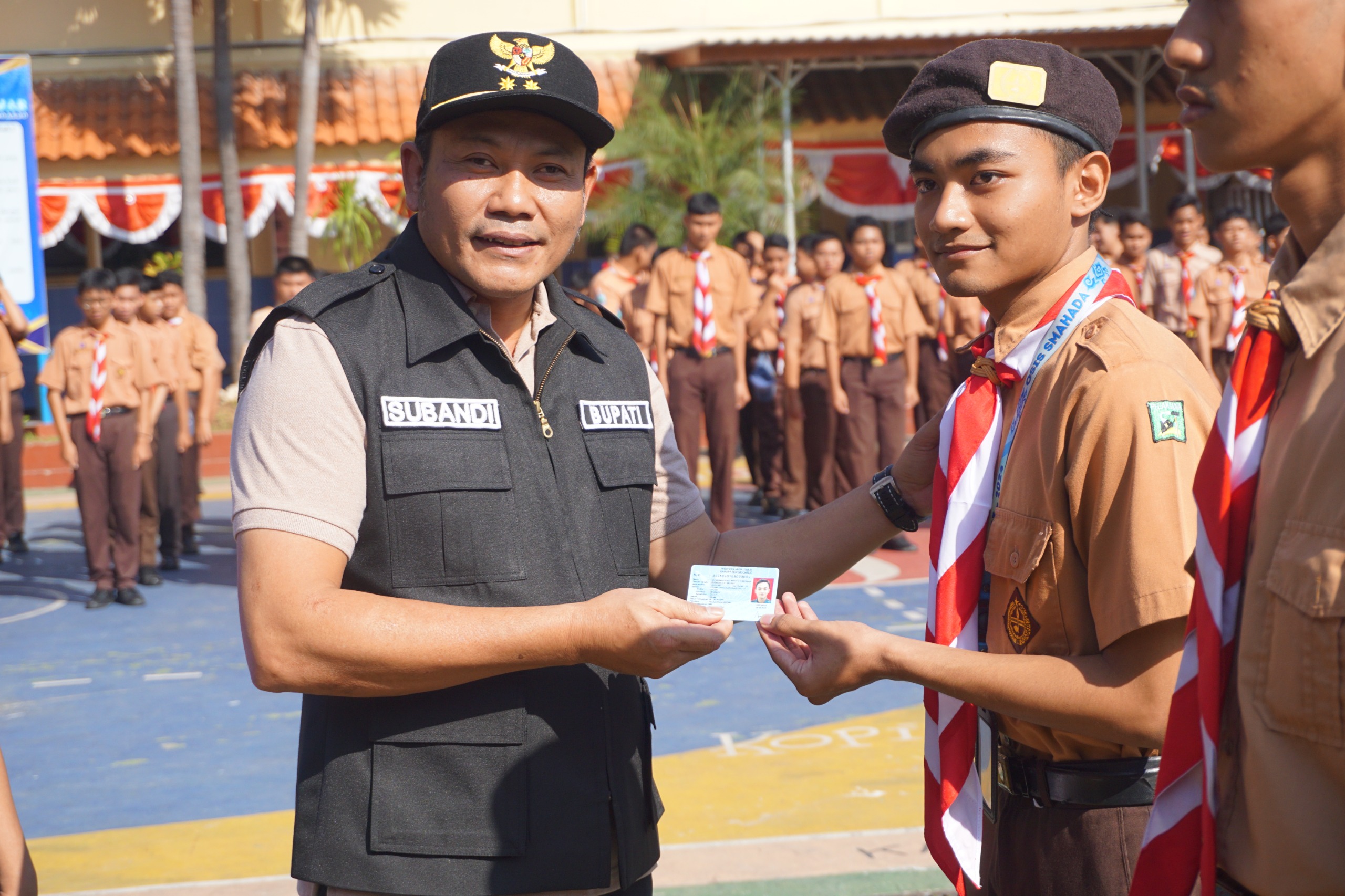 KTP ELEKTRONIK - Plt Bupati Sidoarjo, Subandi menyerahkan E KTP kepada salah satu pelajar saat emput bola dalam program Goes to School itu di SMA Hang Tuah 2 Sidoarjo, Jumat (09/08/2024).