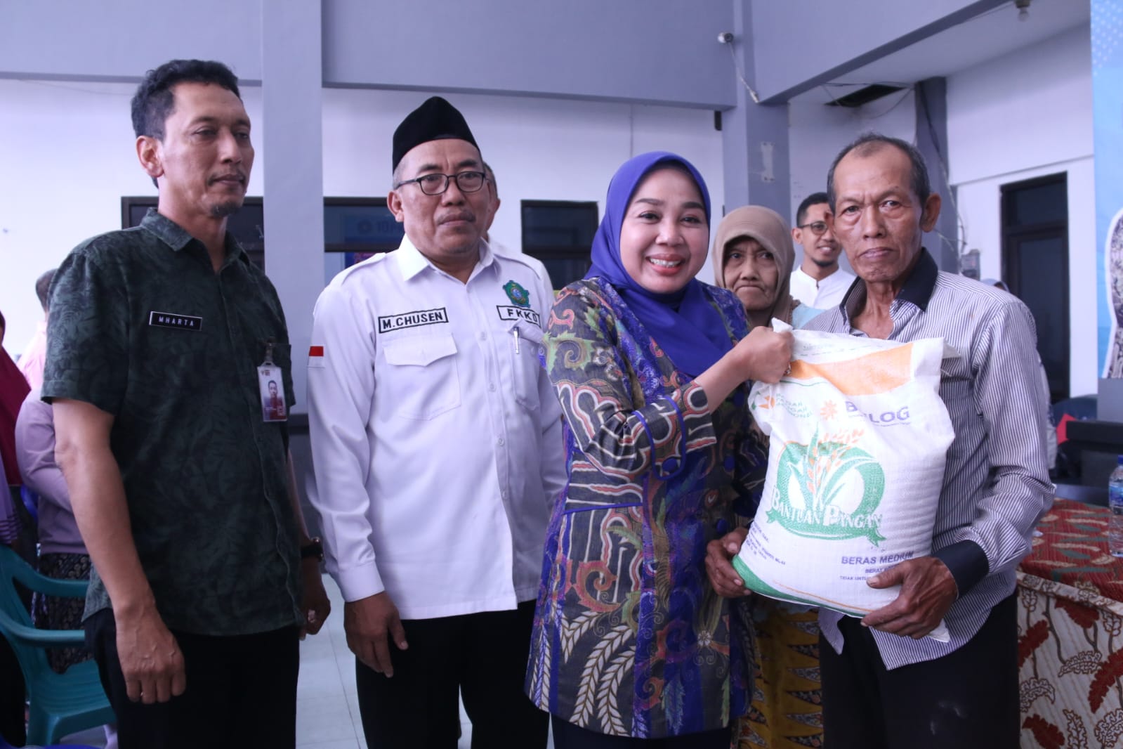 SERAHKAN - Istri Plt Bupati Sidoarjo, dr Sriatun menyerahkan bantuan beras kepada warga di Kecamatan Waru, Rabu (14/02024). 