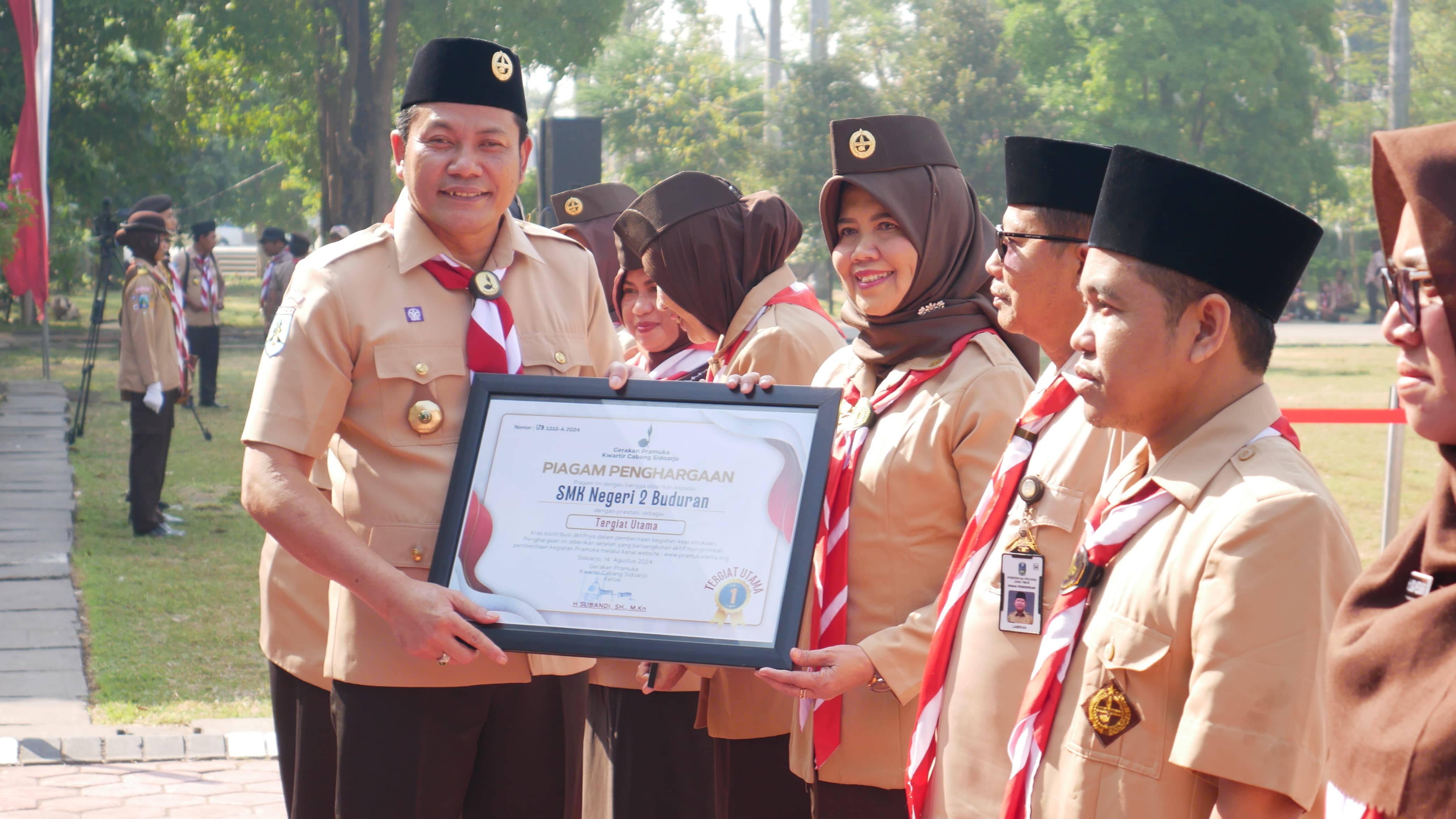 PENGHARGAAN - Plt Bupati Sidoarjo, Subandi memberikan penghargaan kepada para anggota Pramuka usai upacara Hari Pramuka ke 63 Tahun 2024 di Alun - Alun, Sidoarjo, Rabu (14/08/2024). 