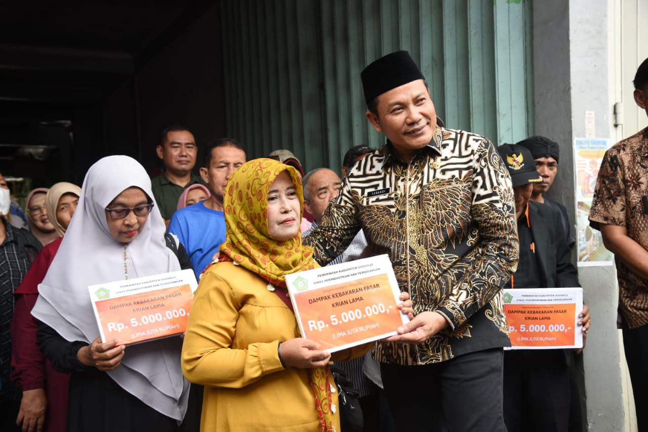 BANTUAN - Pemkab Sidoarjo memberikan Bantuan Sosial (Bansos) ke para pedagang pasar Krian yang stannya terbakar berupa uang Rp 5 juta untuk 297 pemilik stan di Pasar Krian, Sidoarjo, Selasa (10/09/2024). 
