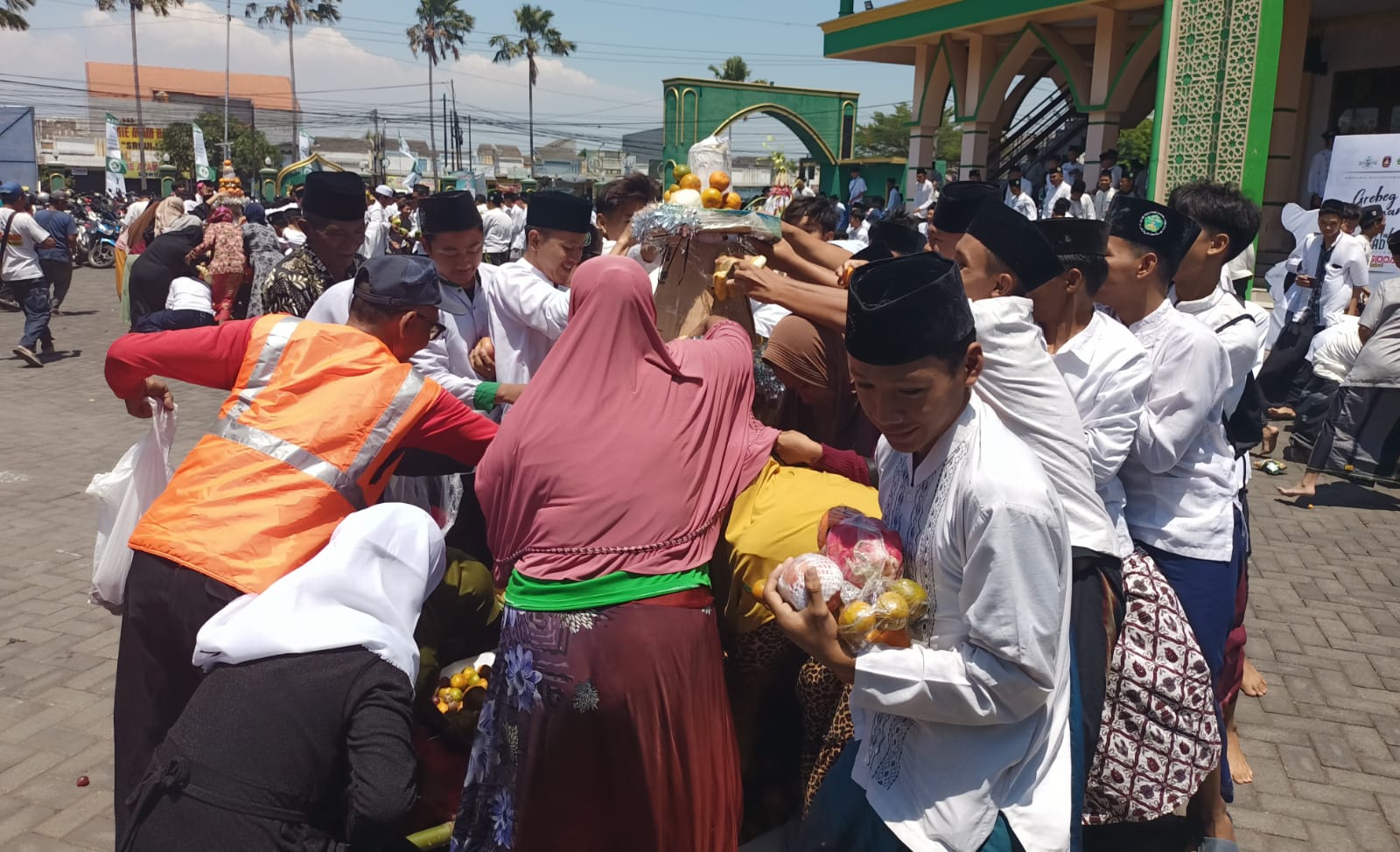 REBUTAN - Ribuan pelajar berebut 6 gunungan buah-buahan dan sayuran saat peringatan Maulid Nabi Muhammad SAW yang digelar SMK YPM 8 Sidoarjo di Masjid Babussalam Dusun Balon, Desa Sidodadi, Kecamatan Candi, Sidoarjo, Sabtu (14/09/2024).